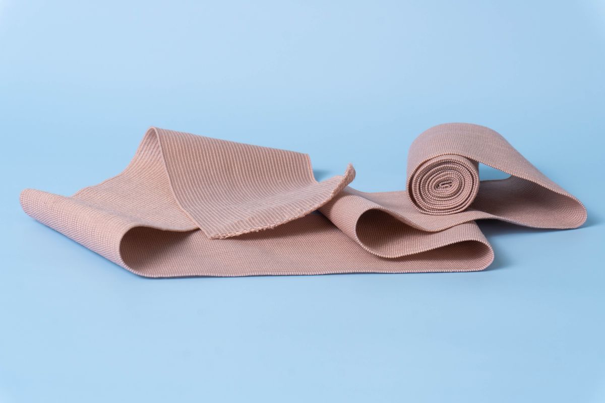 Rolled elastic bandage wrap on a light blue surface