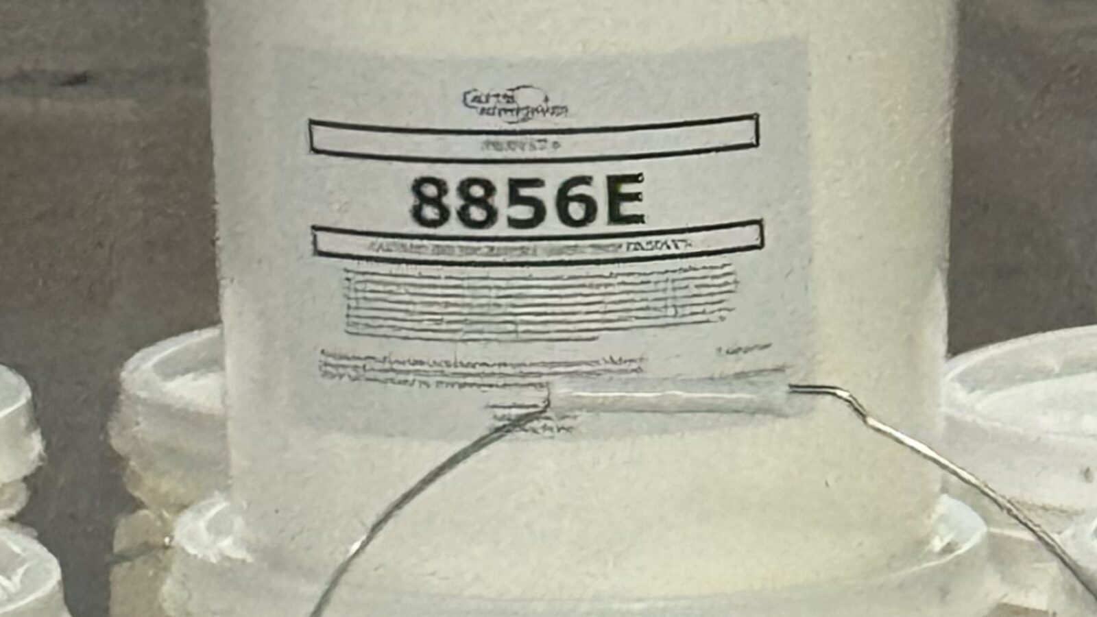 White Cattie Adhesives pails labeled 8856E on a pallet
